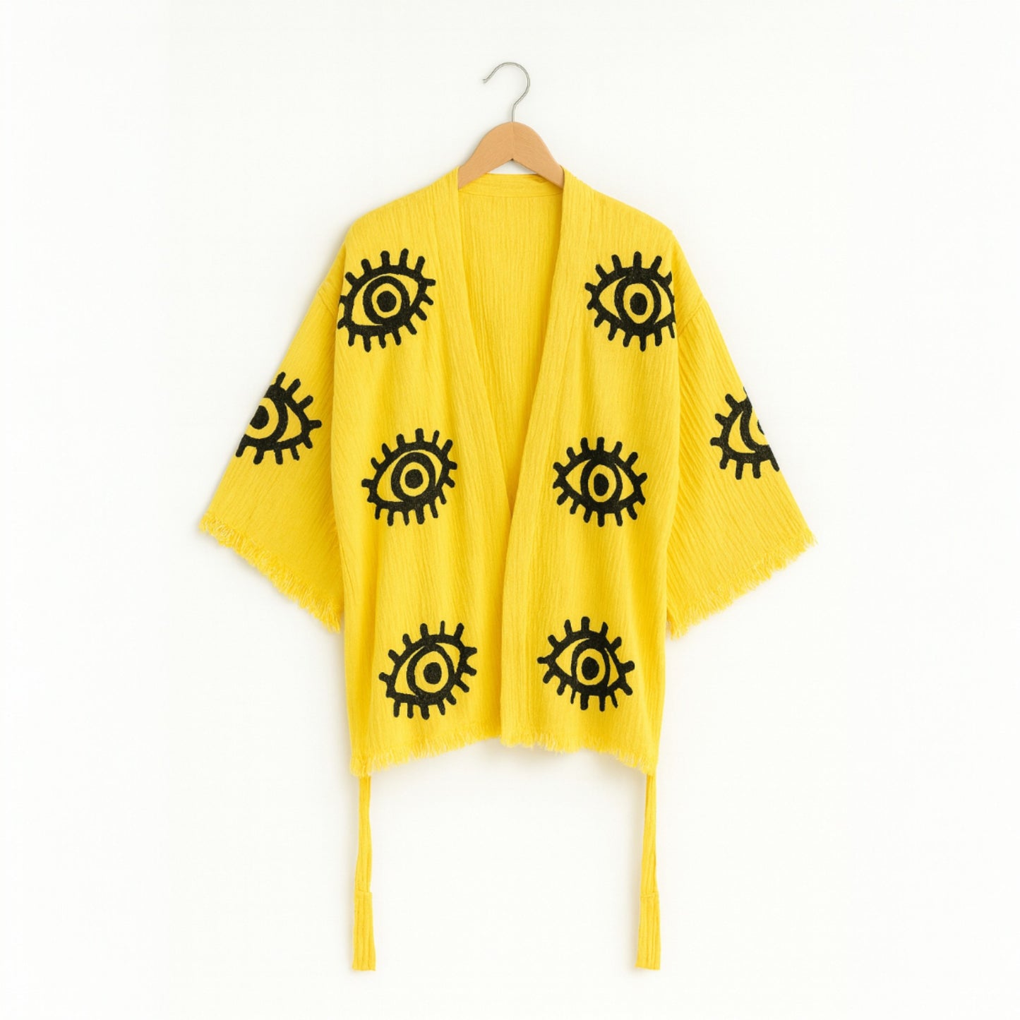Yellow evil eye kimono set  with black eye patterns on a white background