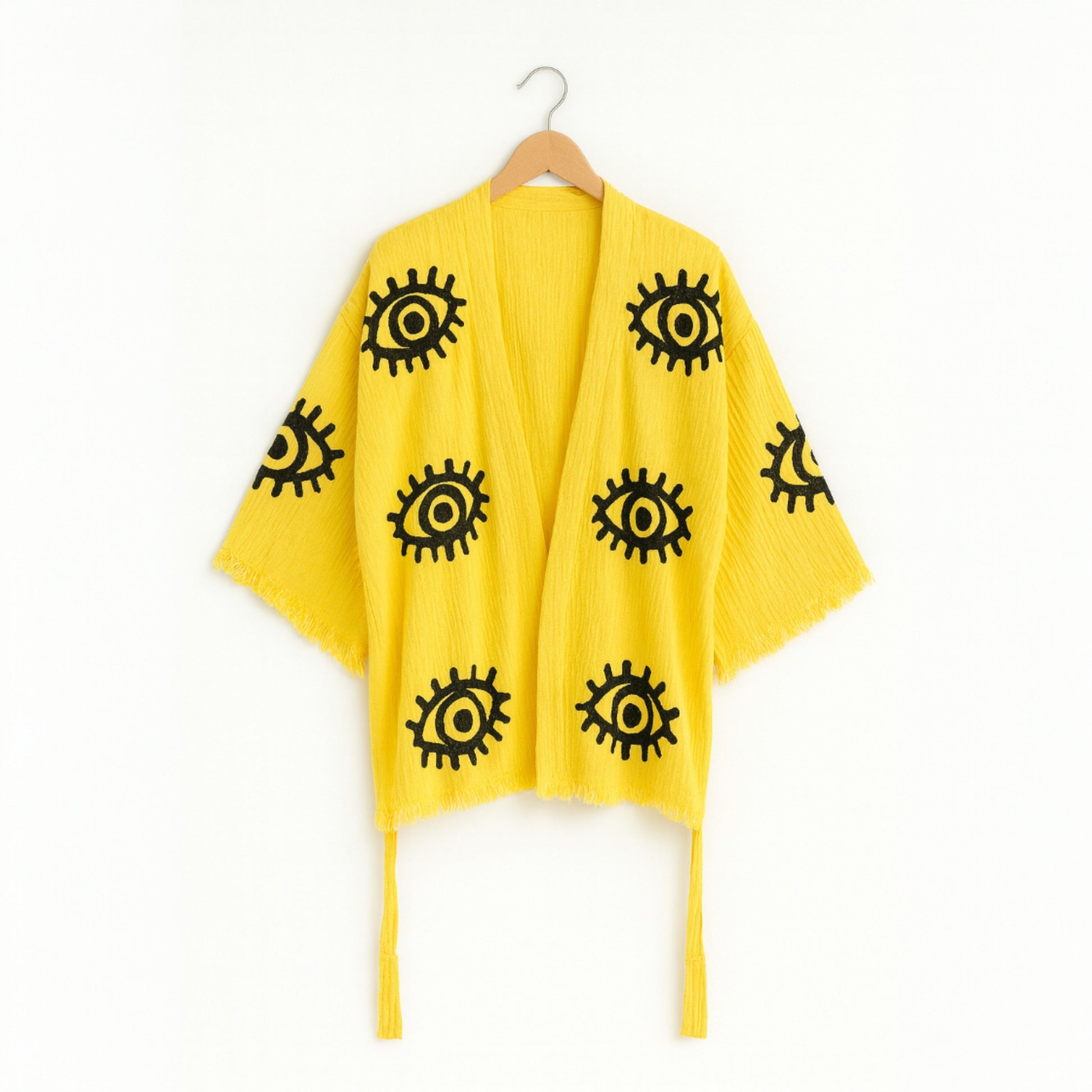 Yellow evil eye kimono set  with black eye patterns on a white background