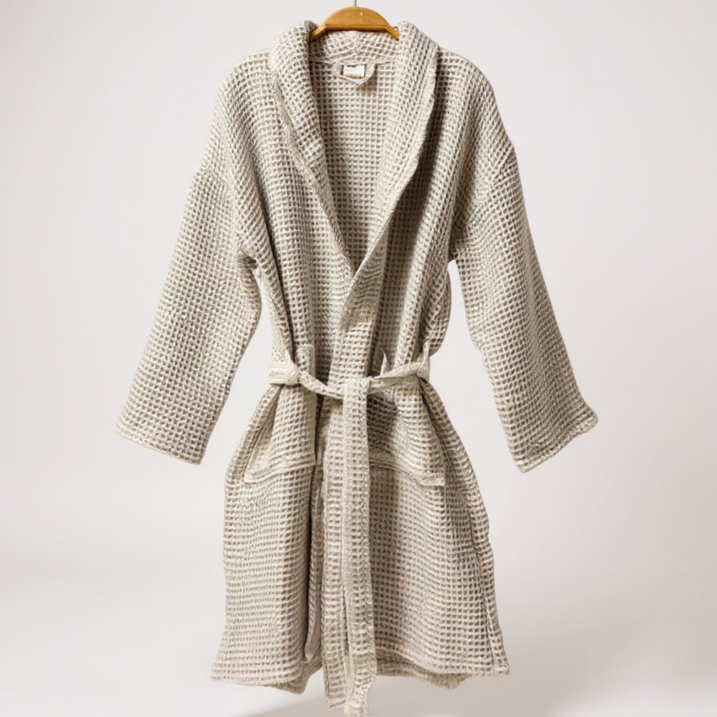 Woven robe on a hanger against a white background