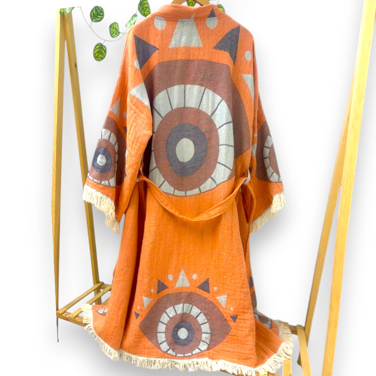 Kimono robes with Evil Eye patterns in orange and blue colors, displayed on hangers.
