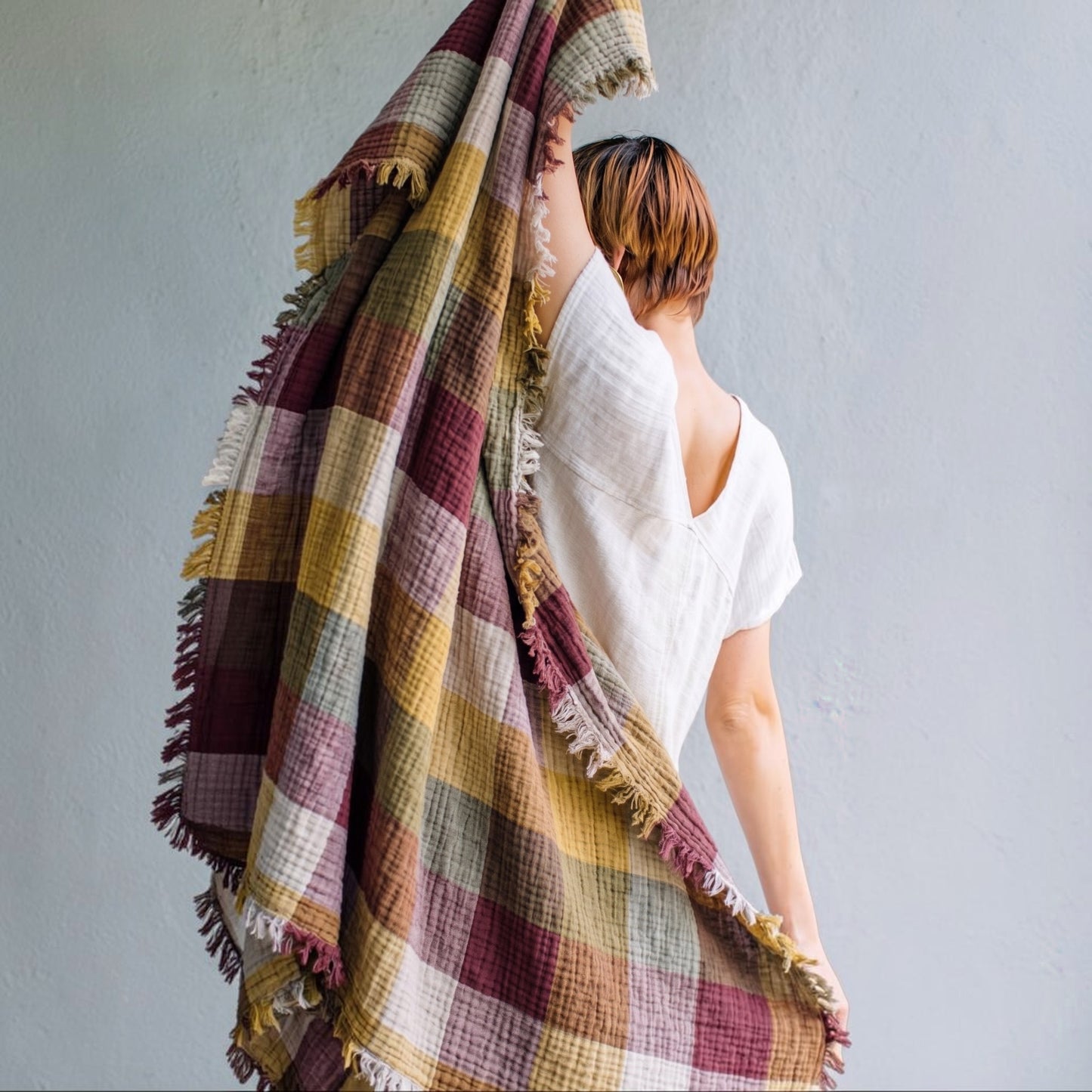Person holding a Cotton Plaid Throw Blanket – Sofa Throw & Picnic Blanket with a neutral background