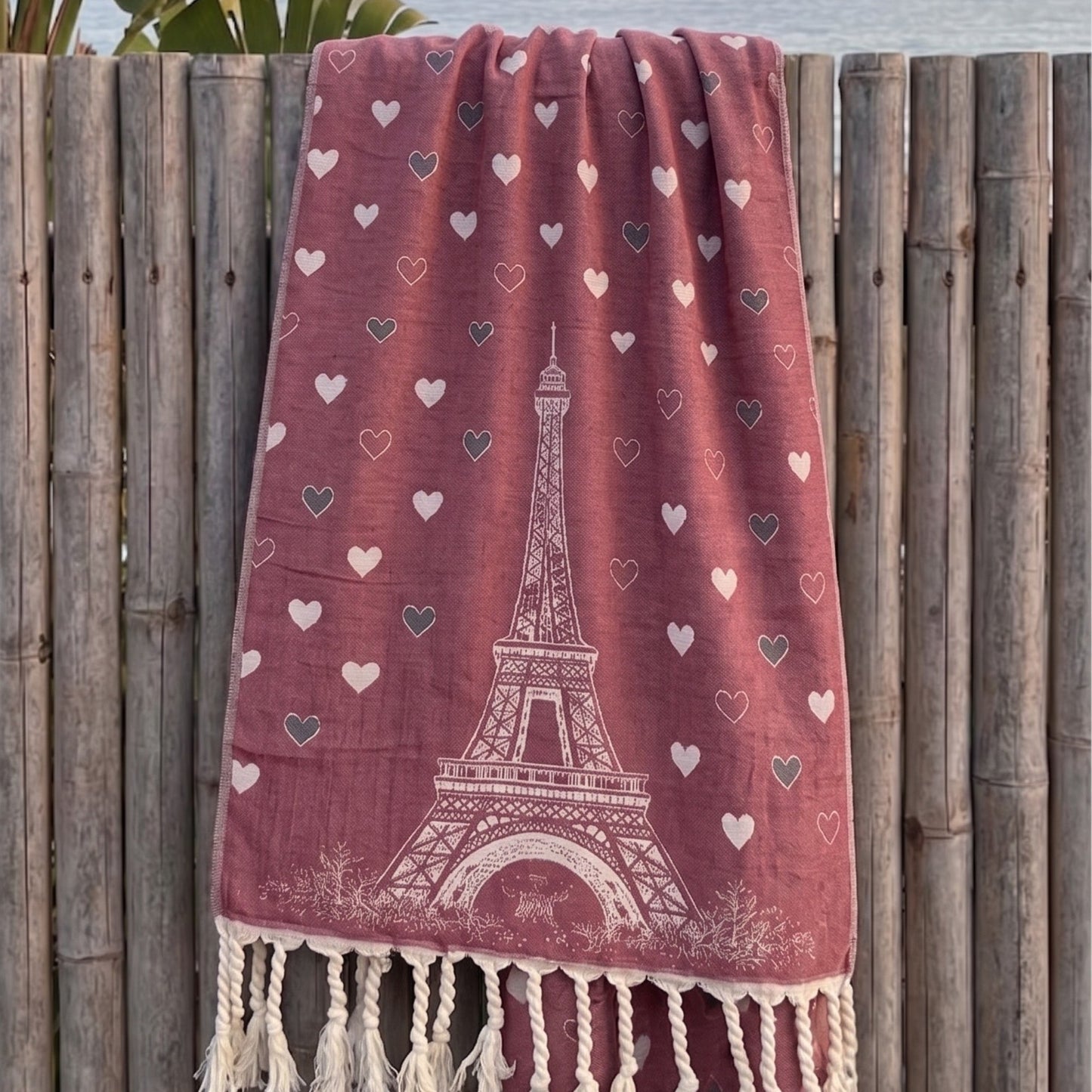 paris love turkish towel pestemal beach towel hanging on a wooden fence.