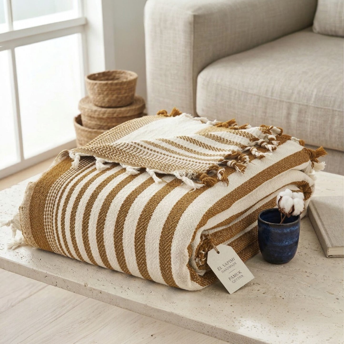 Mustard Striped blanket with tassels on a wooden surface near a sofa (Anatolia Signature Stripe Handwoven Cotton Blanket)
