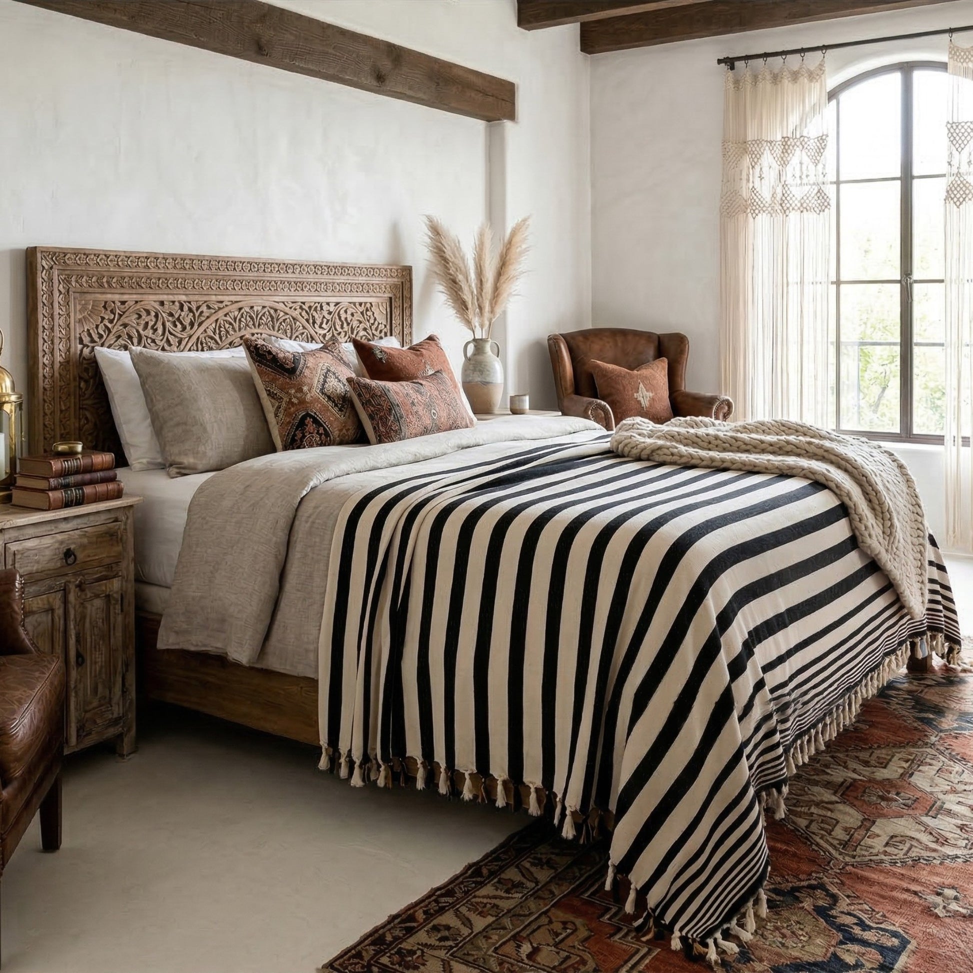 Cozy bedroom with wooden bed, striped blanket, and armchair.