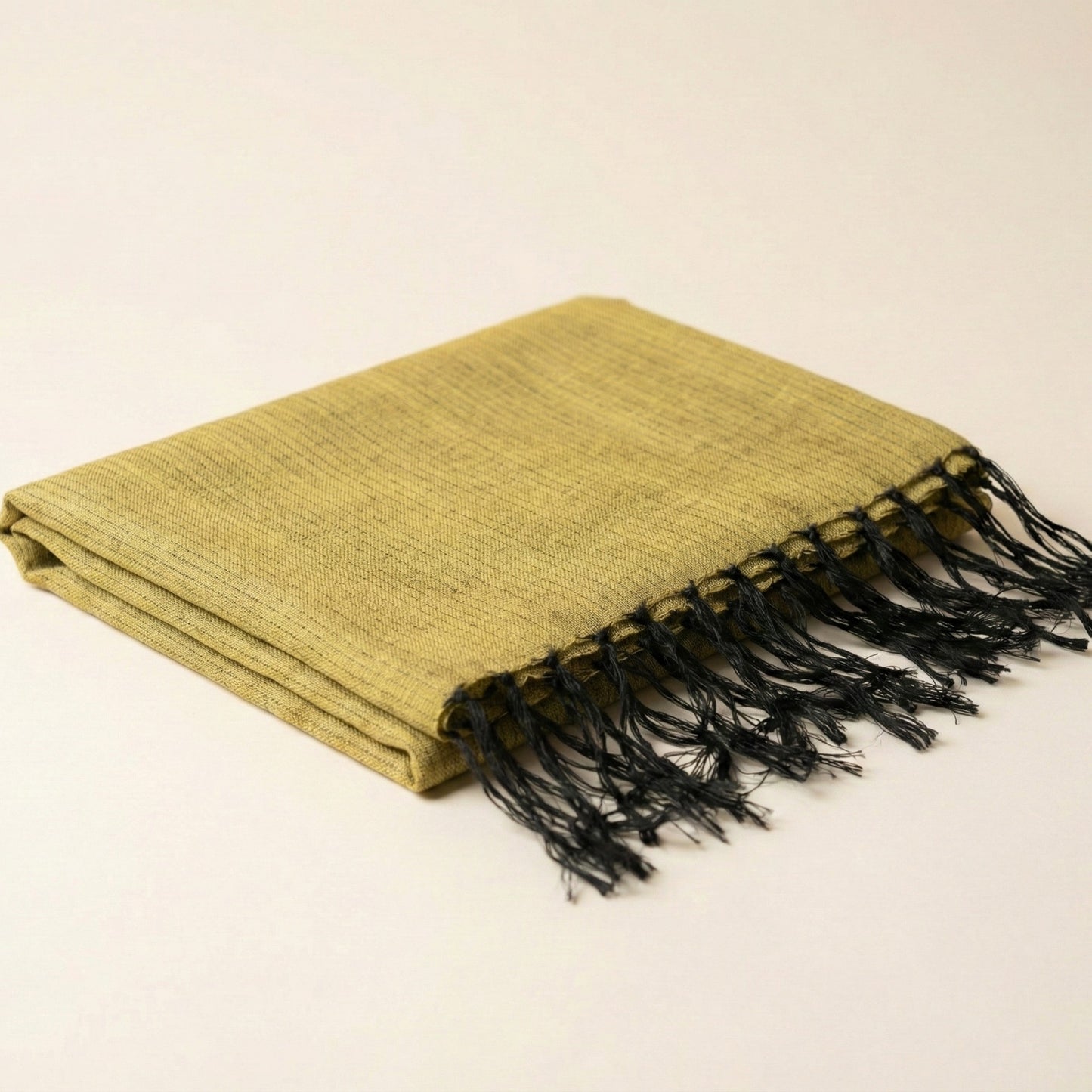 Green Antakya Handwoven Silk Scarf with black fringe on a beige background