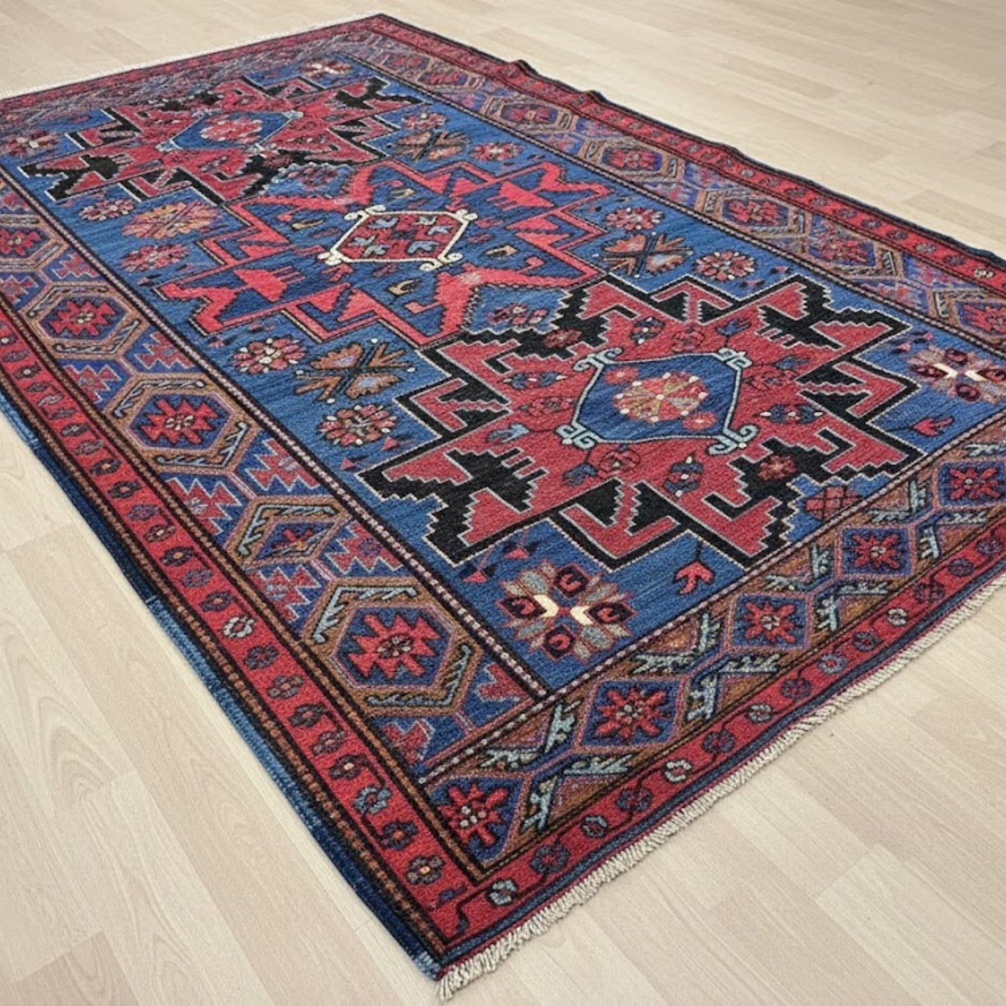 Decorative Antique Caucasian Sumak Kilim – Over 100 Years Old | Handwoven with Natural Root Dye with intricate patterns on a wooden floor
