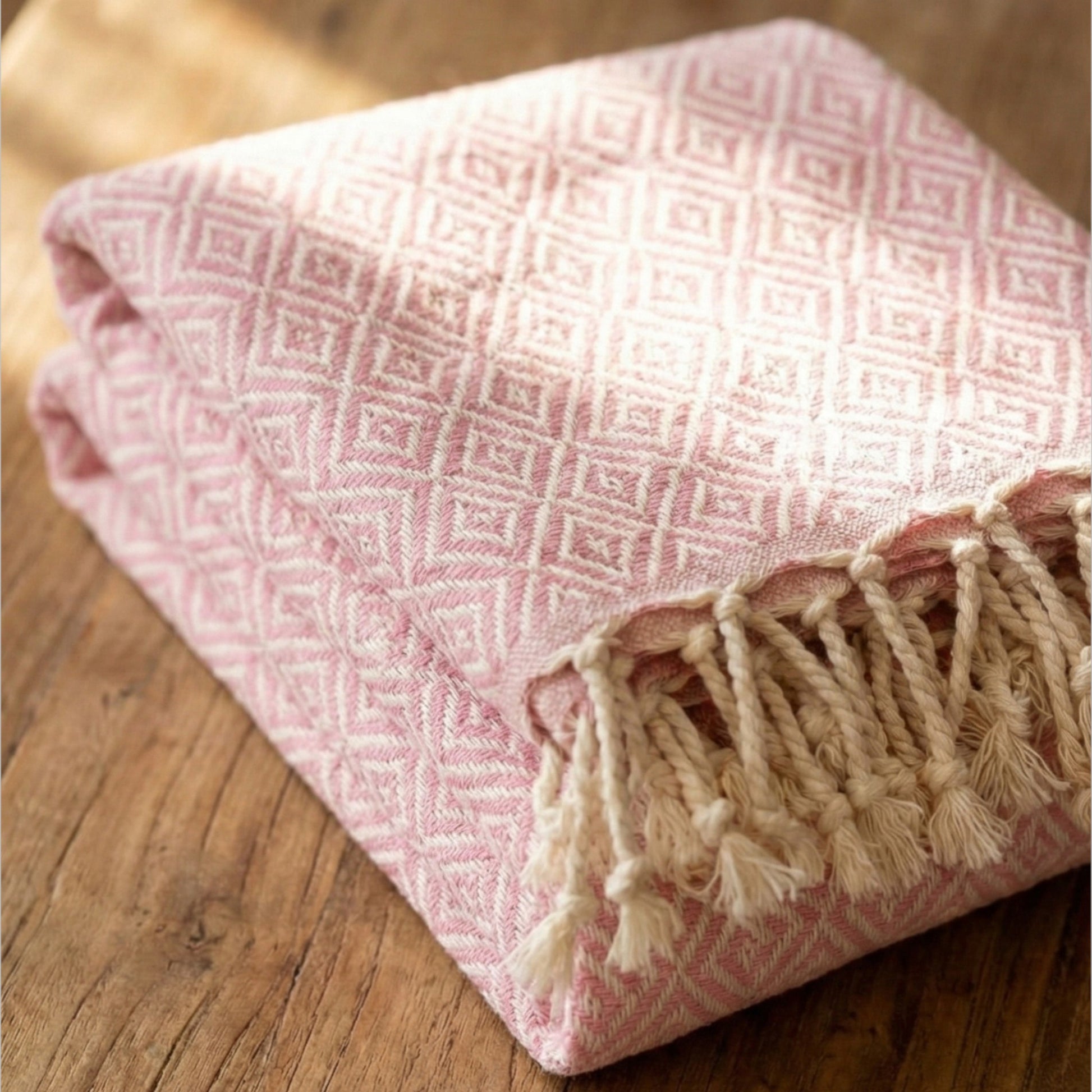 Pink textured Diamond Design Turkish Hand Towel  Handwoven Natural Cotton Sustainable Anatolian Craft with tassels on a wooden surface
