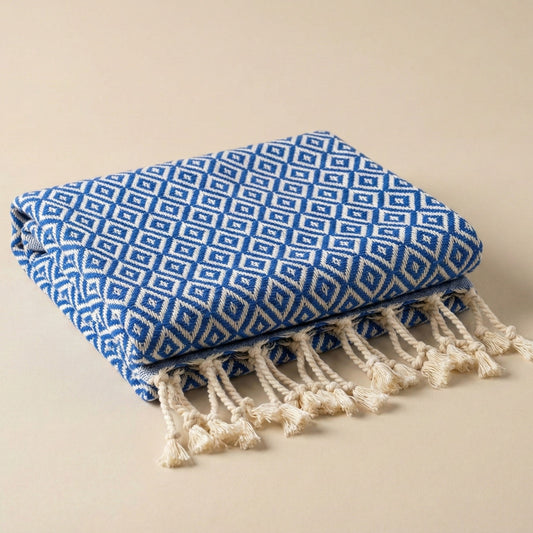 Blue and white patterned Diamond Design Turkish Hand Towel — Handwoven | Natural Cotton | Sustainable Anatolian Craft with tassels on a beige background