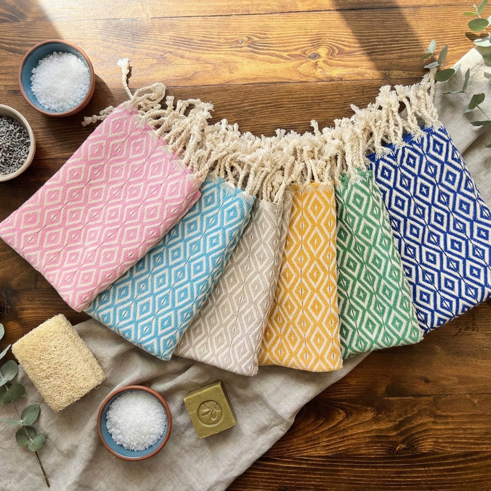 Colorful patterned Diamond Design Turkish Hand Towels  Handwoven Natural Cotton Sustainable Anatolian Craft on a wooden surface with small bowls and a bar of soap.