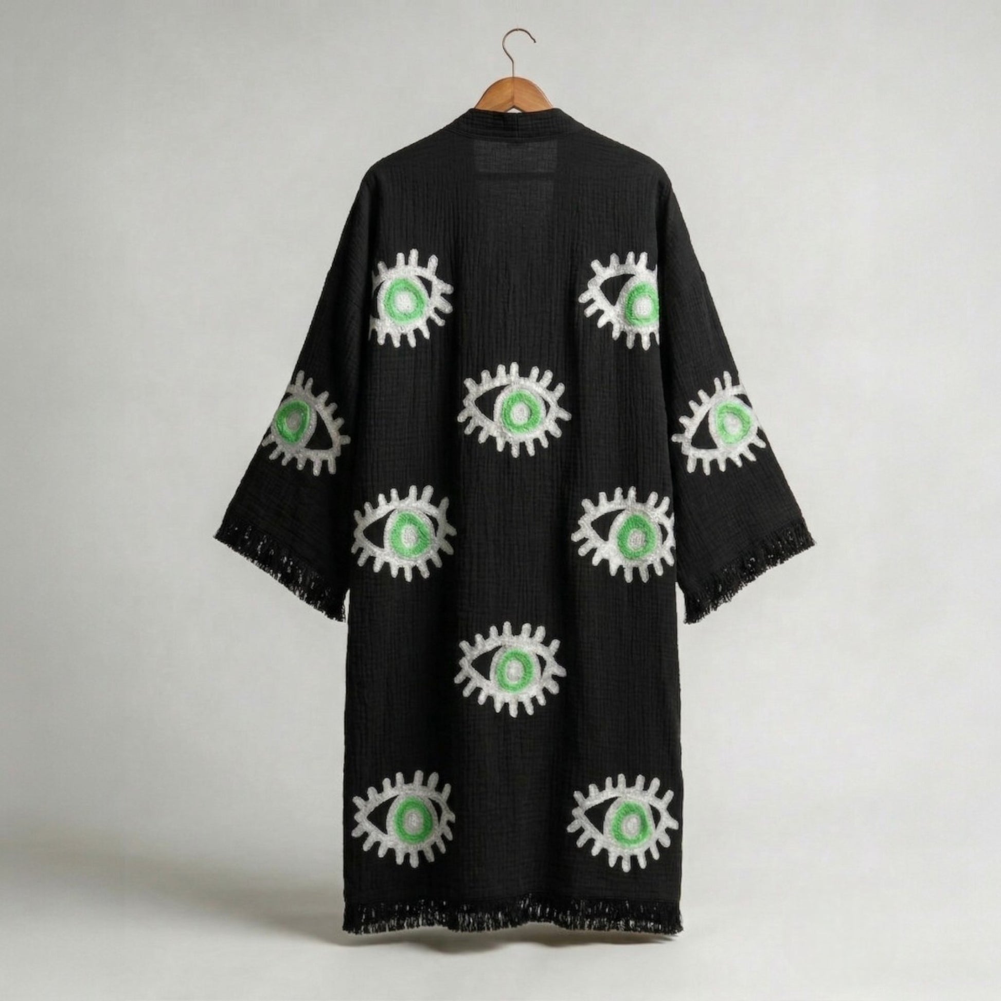 hand woven evil eye turkish cotton kimono robe black on a hanger against a white background