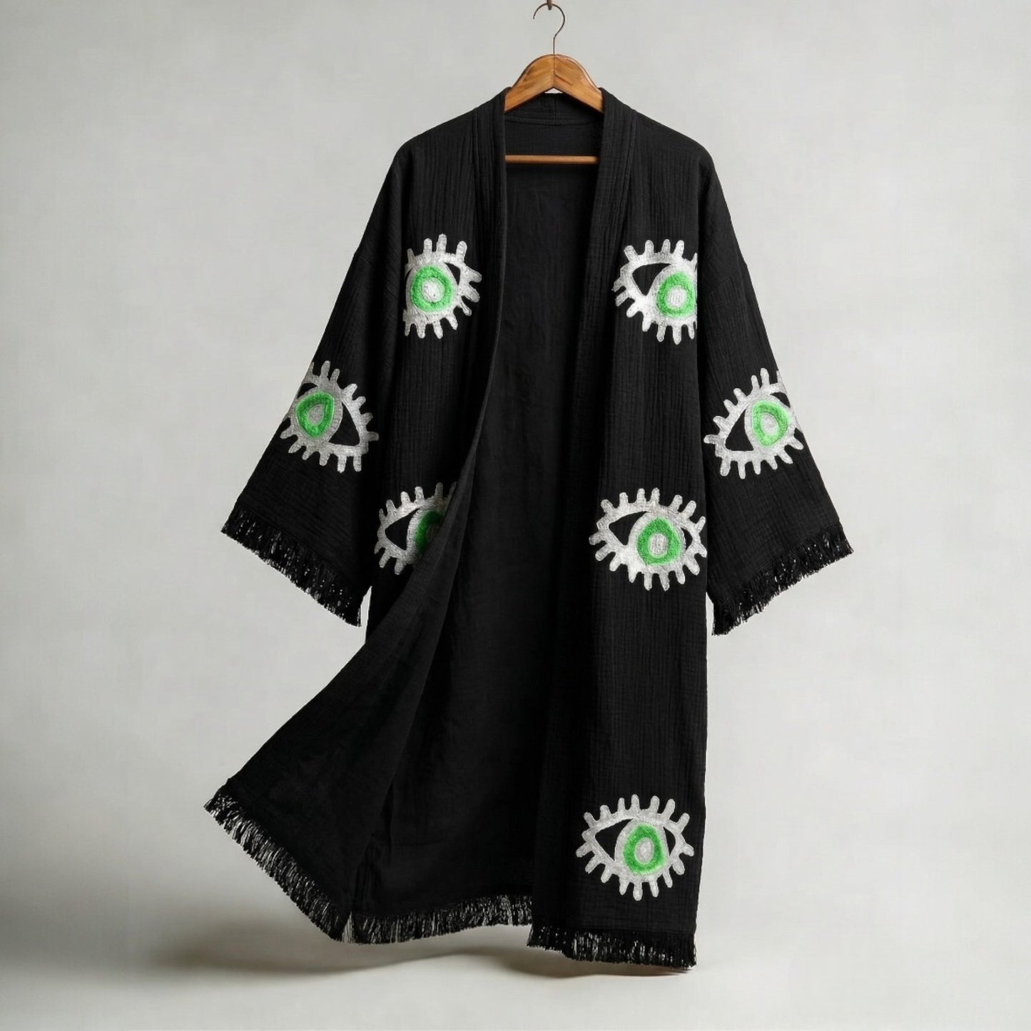 hand woven evil eye turkish cotton kimono robe black on a hanger against a gray background