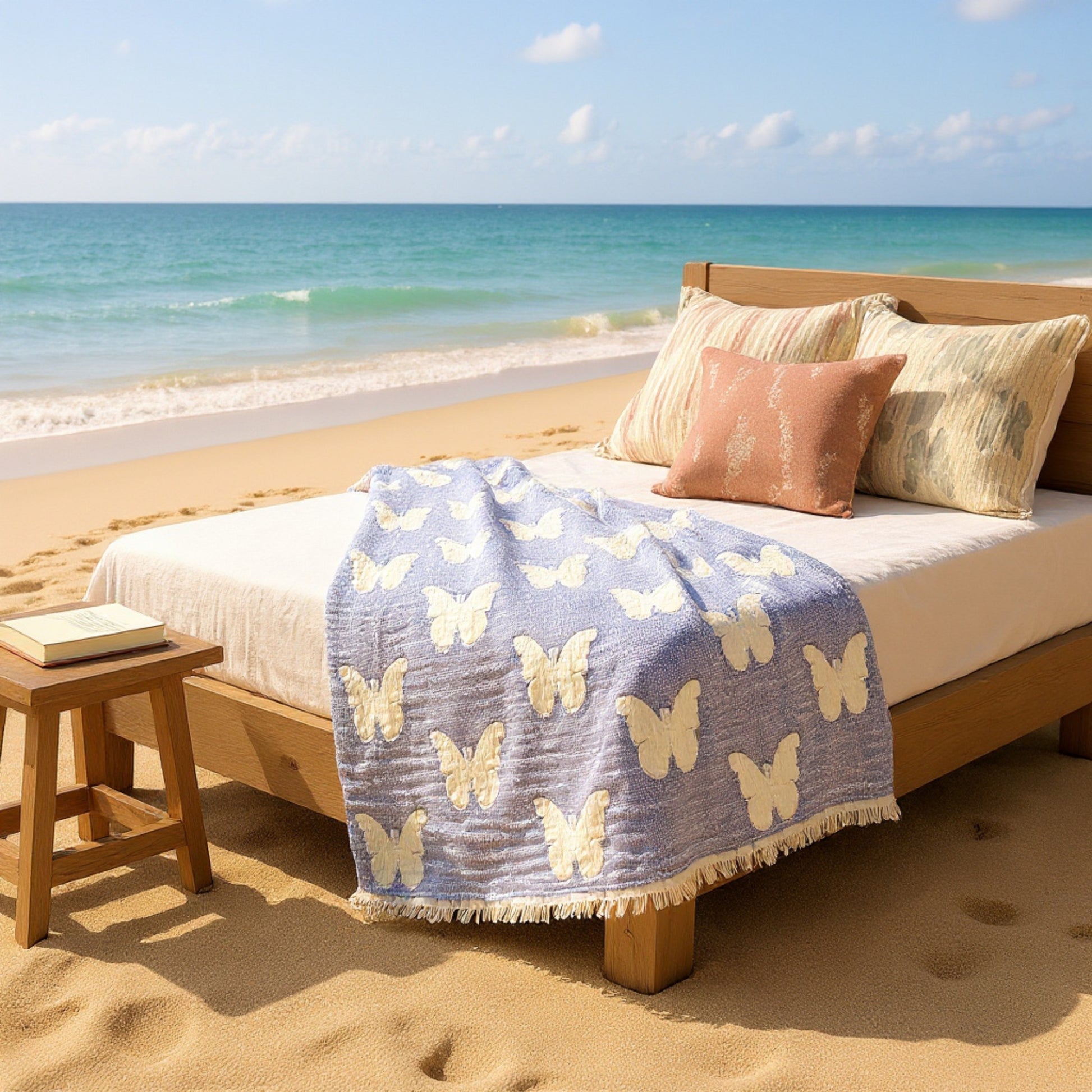 Handmade handwoven natural cotton muslin Turkish towel in blue with white butterfly design, displayed on a beach bed