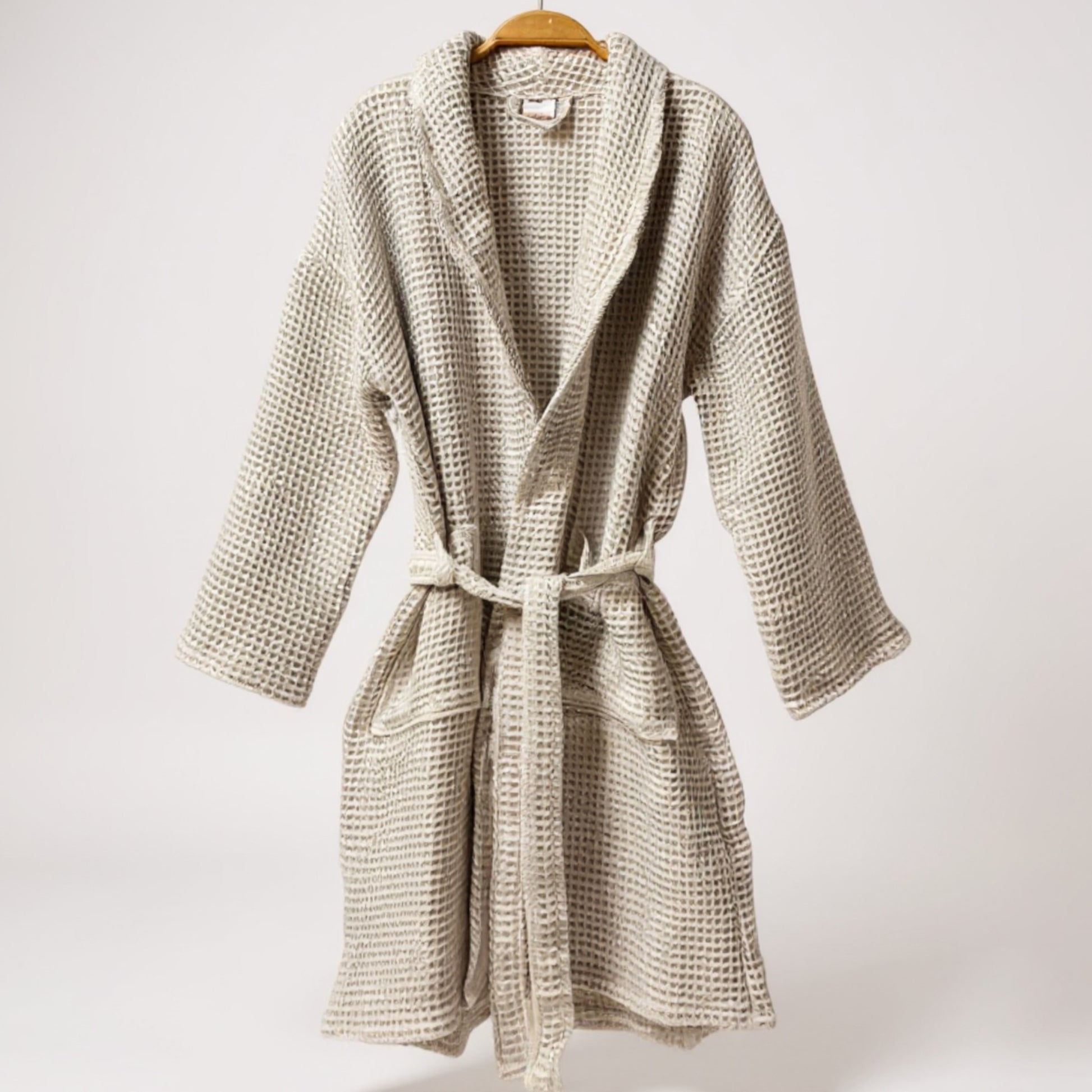 Woven robe on a hanger against a white background