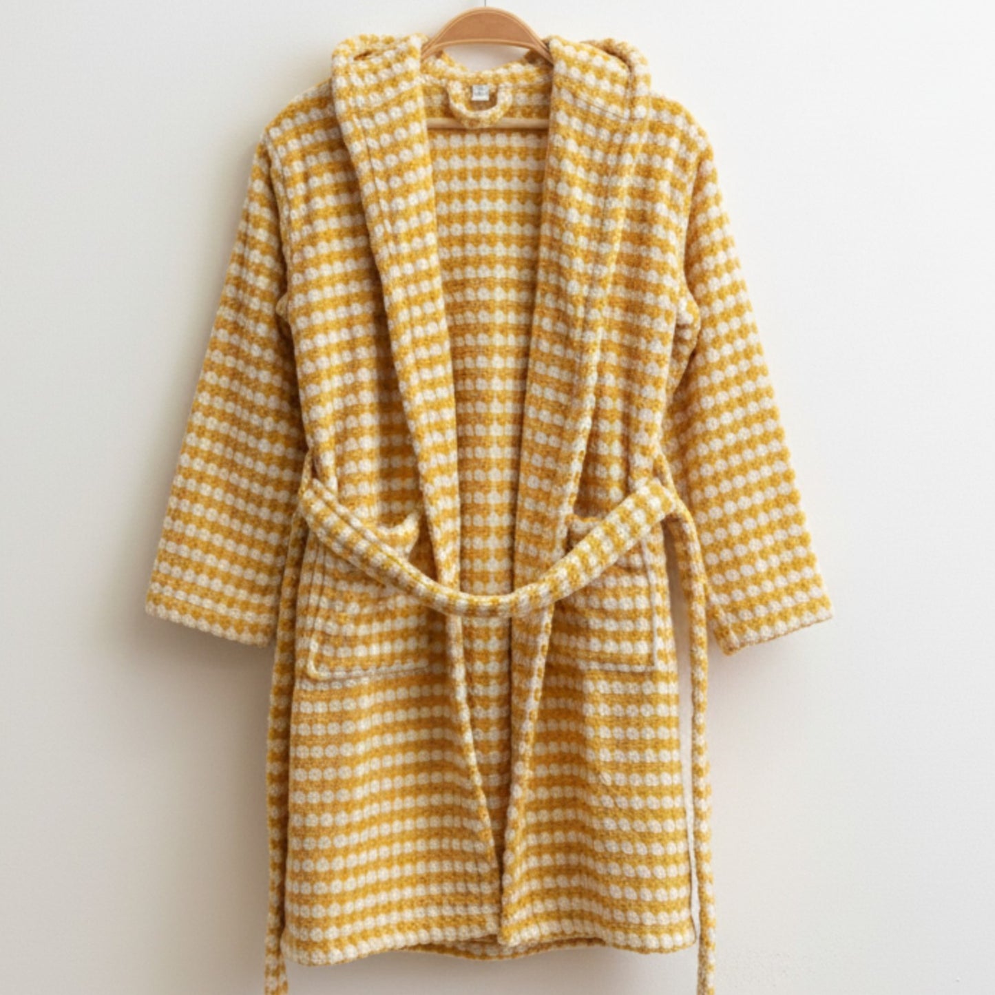 Handwoven Natural Turkish Cotton Terry Kids Bathrobe – PomPom Design Golden Yellow Hooded on a hanger against a light background