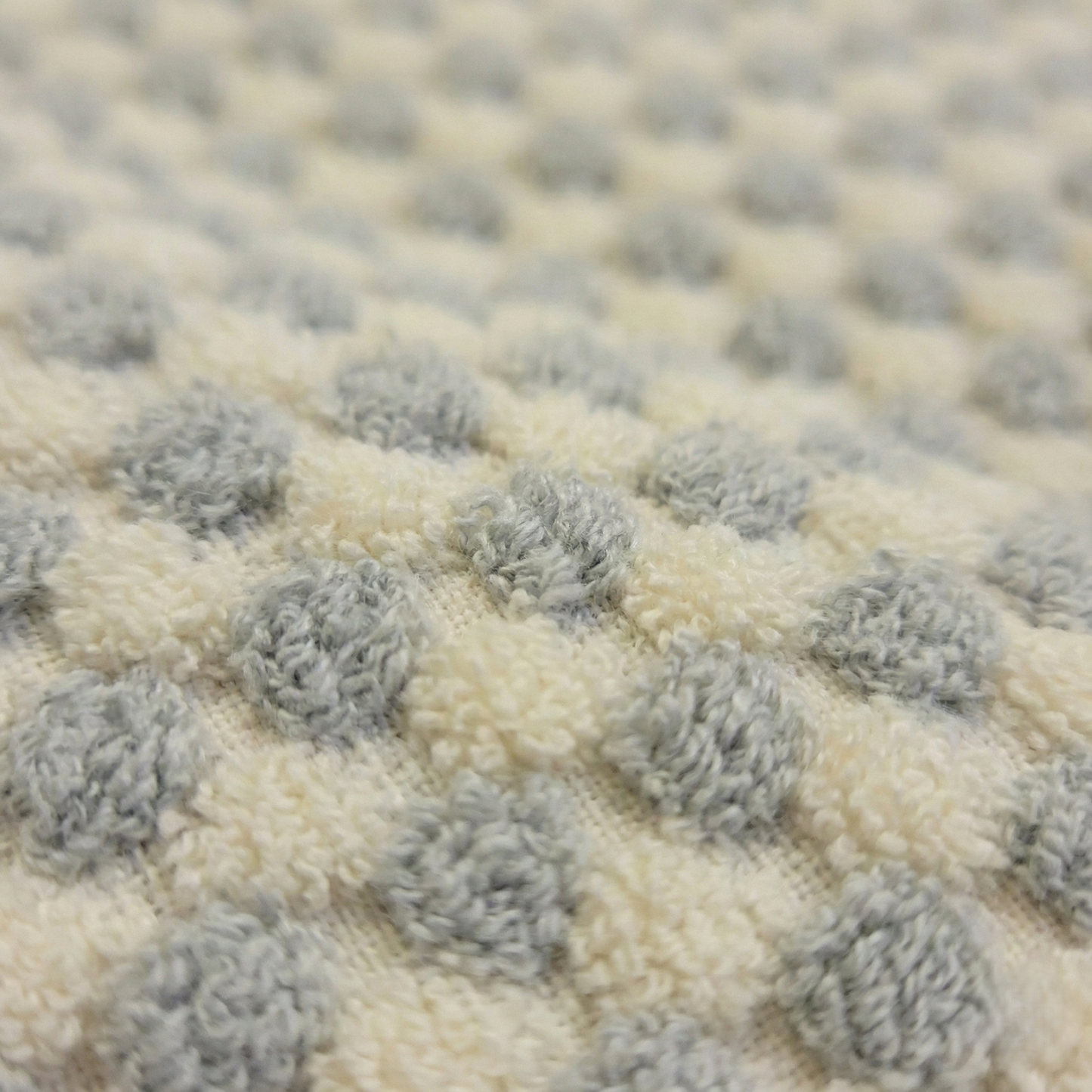 Close-up of a textured rug with gray and beige pattern of Handwoven Turkish Terry Bathrobe Grey Dotted Shawl Collar