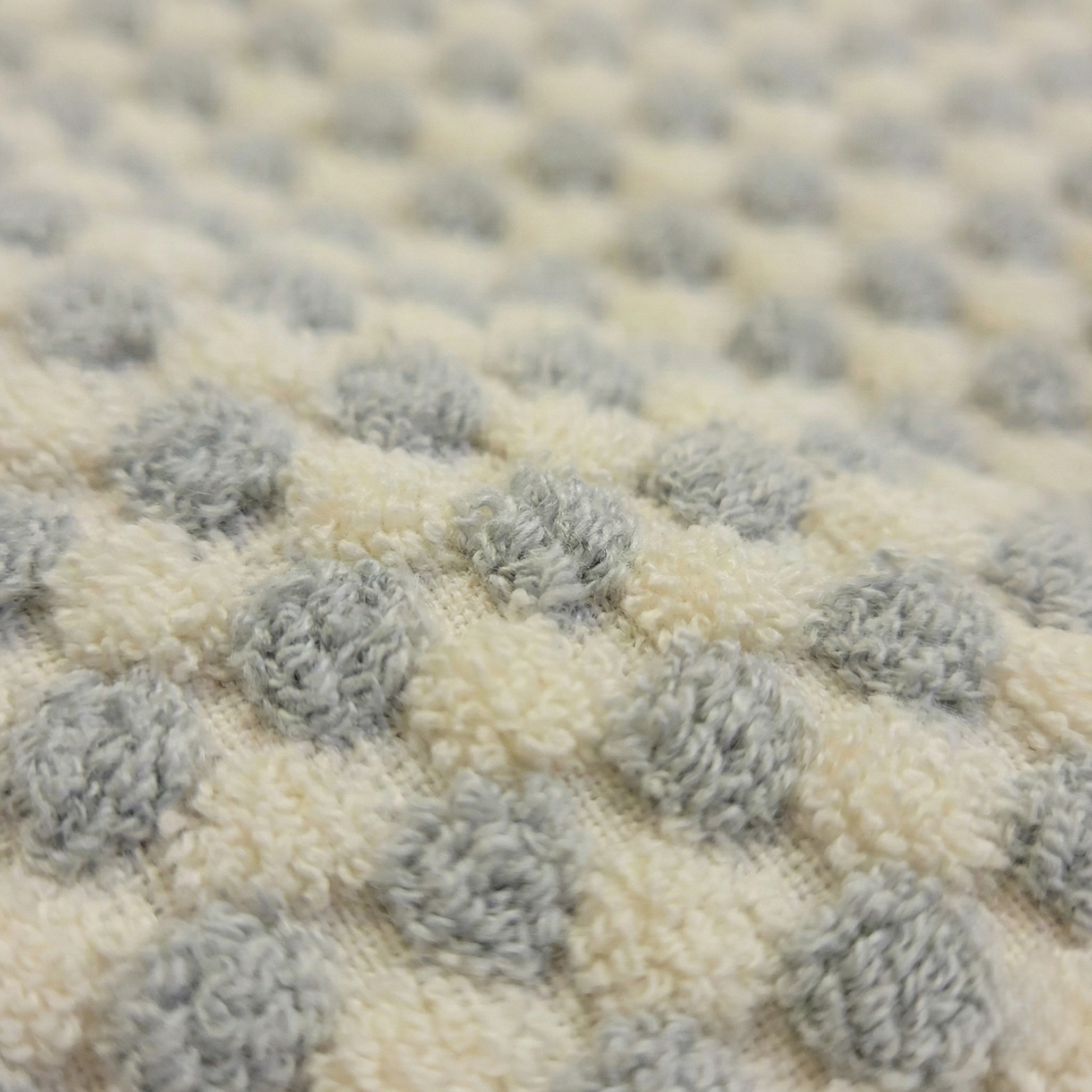 Close-up of a textured rug with gray and beige pattern of Handwoven Turkish Terry Bathrobe Grey Dotted Shawl Collar